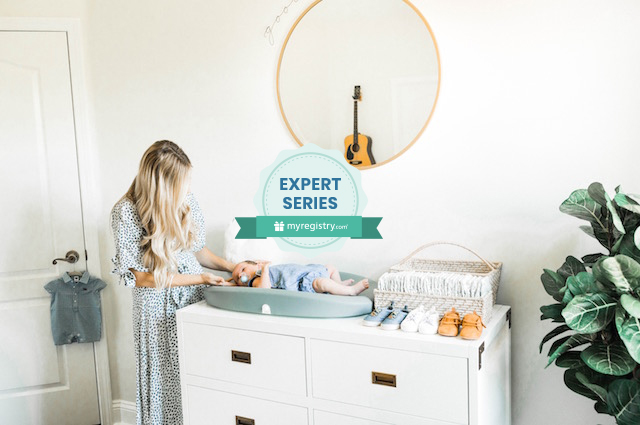 Baby Registry Must-Haves for a Safe, Functional Nursery, women, presumably a mother, standing in a room changing a baby who lying on a changing pad that's on a white dresser.